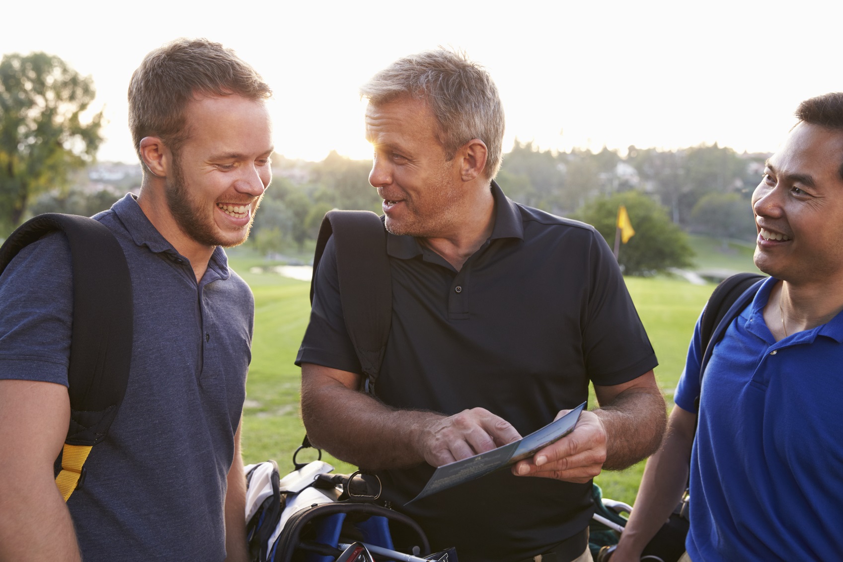 Group Of Male Golfers Marking Scorecard At End Of Round