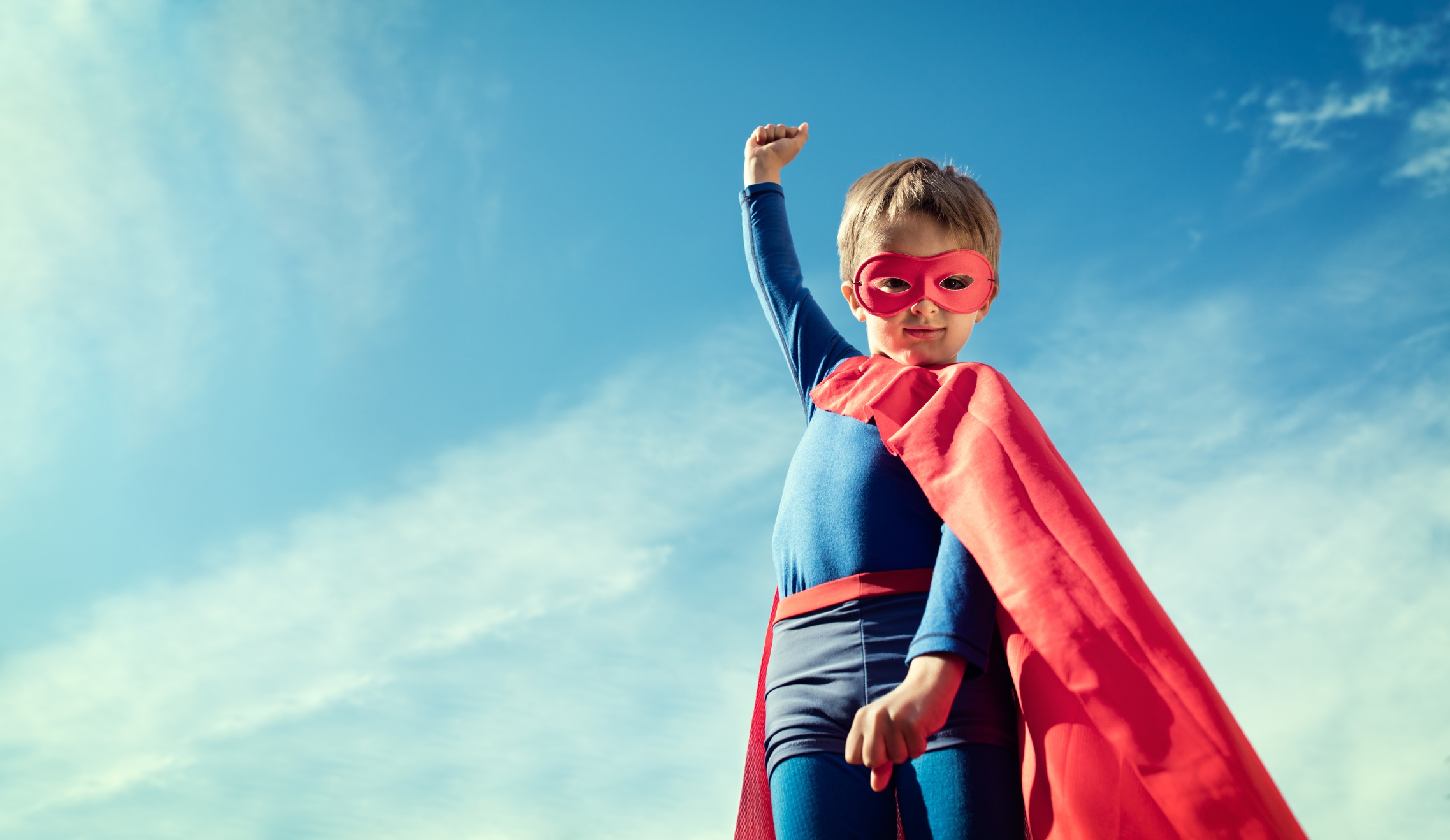 Superhero kid in red cape and mask